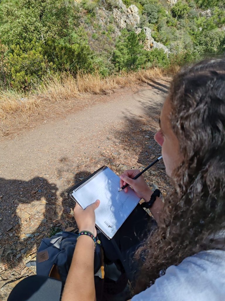 Participante dibujando el paisaje en su cuaderno de campo durante la Georruta de Los Molinos