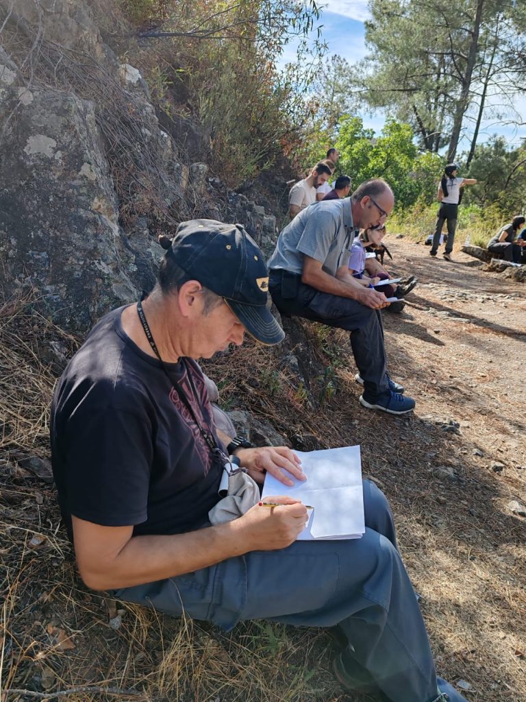 Participantes sentados junto a un afloramiento dibujando durante la Georruta de Los Molinos